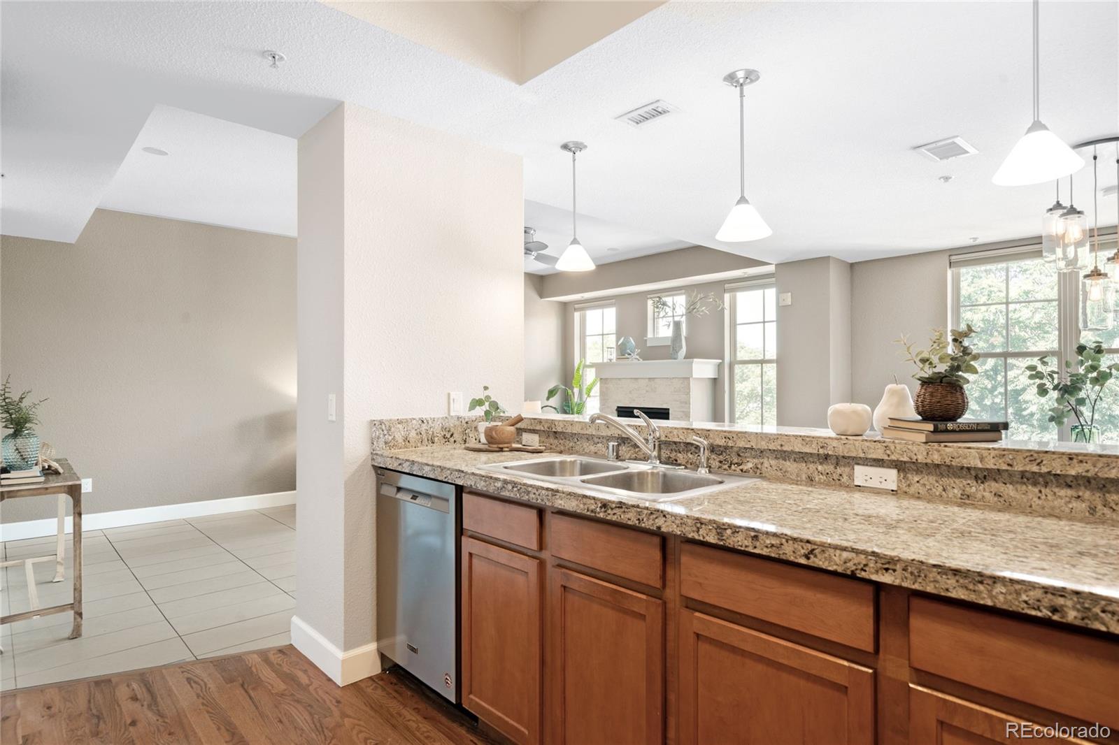 1699 North Downing Street, Unit 306 Denver, CO 80218 - Photo 14 of 26 a kitchen with granite countertop a sink a counter space and wooden floor