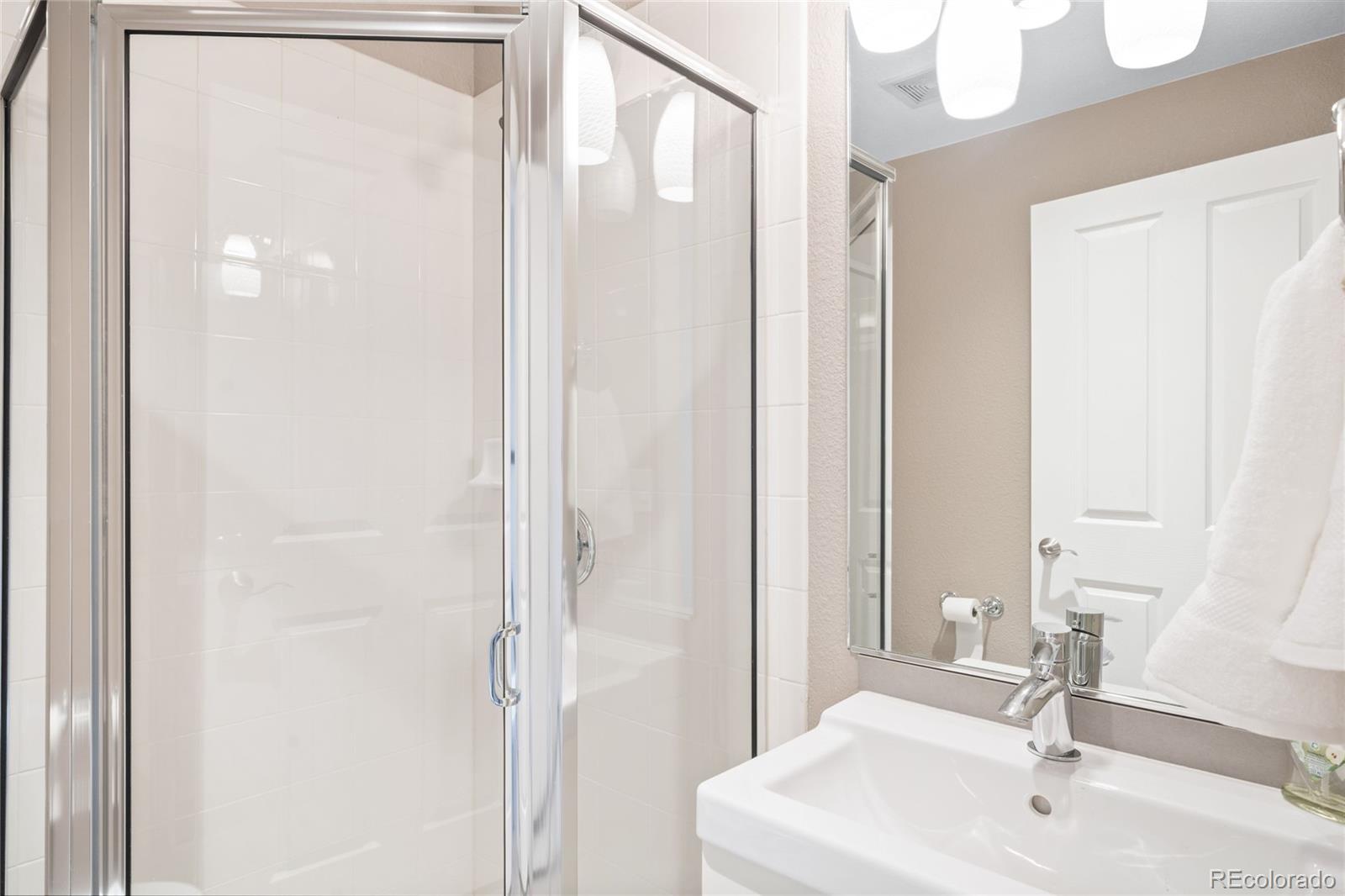 1699 North Downing Street, Unit 306 Denver, CO 80218 - Photo 16 of 26 a bathroom with a sink a mirror and a shower