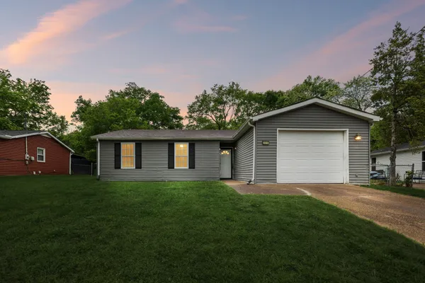 a house with green field in front of it