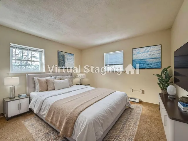 a bedroom with a bed and a flat tv screen on the dresser