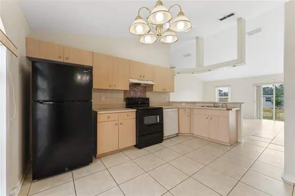 a kitchen with a refrigerator sink and cabinets