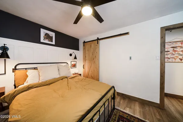 a bedroom with a bed and wooden floor