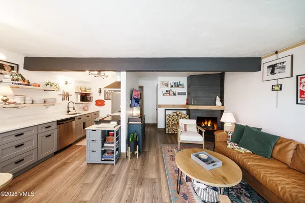 a living room with furniture a rug and kitchen view
