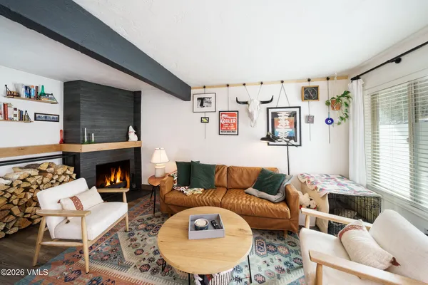 a living room with furniture a fireplace and a large window