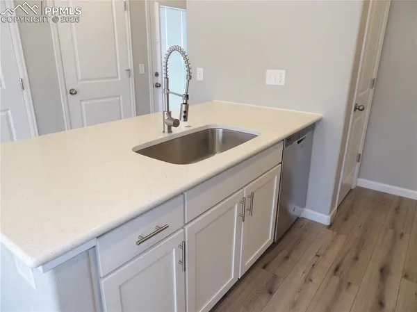 a kitchen with a sink and wooden floor