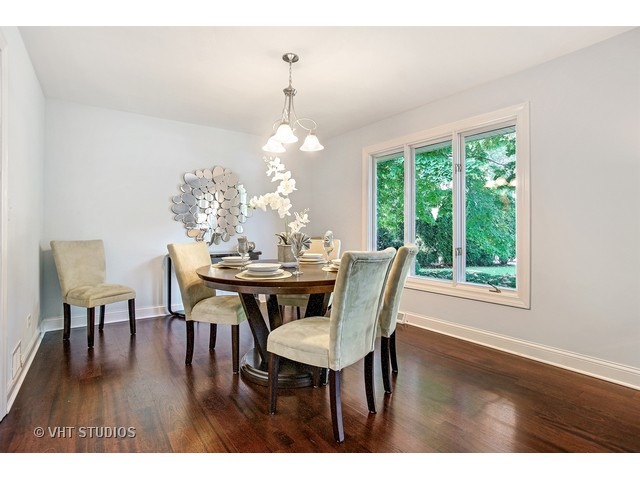 3720 Wilke Road Rolling Meadows, IL 60008 - Photo 3 of 25 a view of a dining room with furniture a chandelier and wooden floor