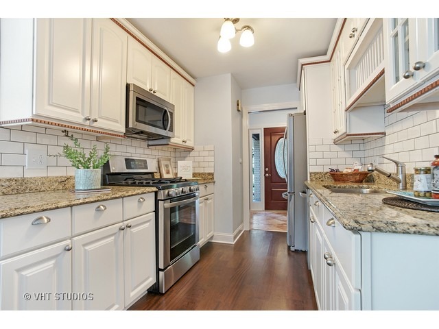 3720 Wilke Road Rolling Meadows, IL 60008 - Photo 10 of 25 a kitchen with stainless steel appliances granite countertop a stove top oven a sink dishwasher and a microwave oven with white cabinets