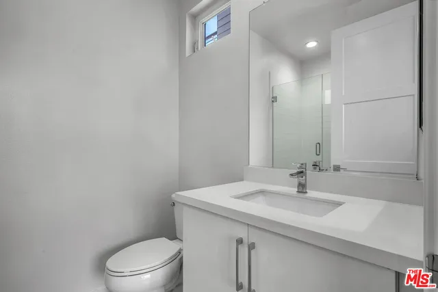 a bathroom with a sink a toilet a mirror and vanity