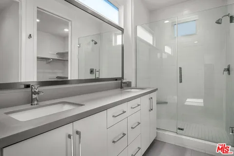a bathroom with double sink and a mirror
