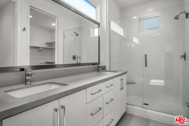 a bathroom with double sink and a mirror