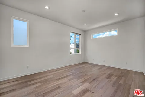 a view of empty room with window and wooden floor