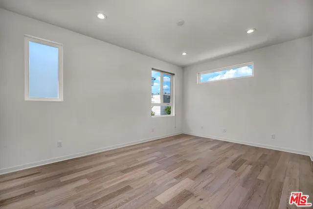 a view of empty room with window and wooden floor