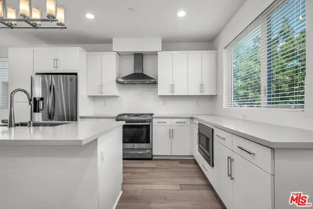a kitchen with stainless steel appliances granite countertop a sink and a stove
