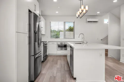 a kitchen with stainless steel appliances a sink stove and refrigerator