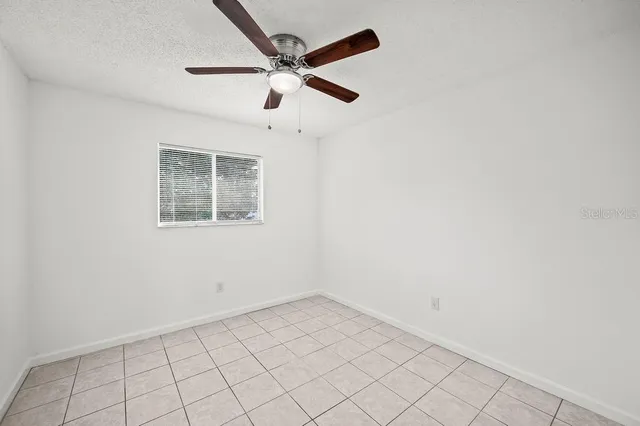 an empty room with a ceiling fan
