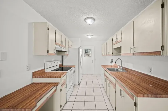 a kitchen with stainless steel appliances a sink stove and cabinets