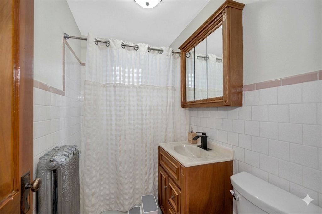 481 Lagrange Street Boston, MA 02132 - Photo 15 of 32 a bathroom with a sink a toilet and shower