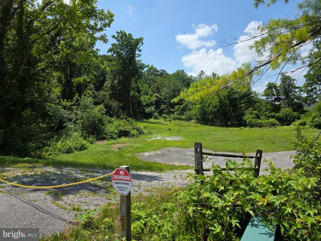 a sign board with a house in the background
