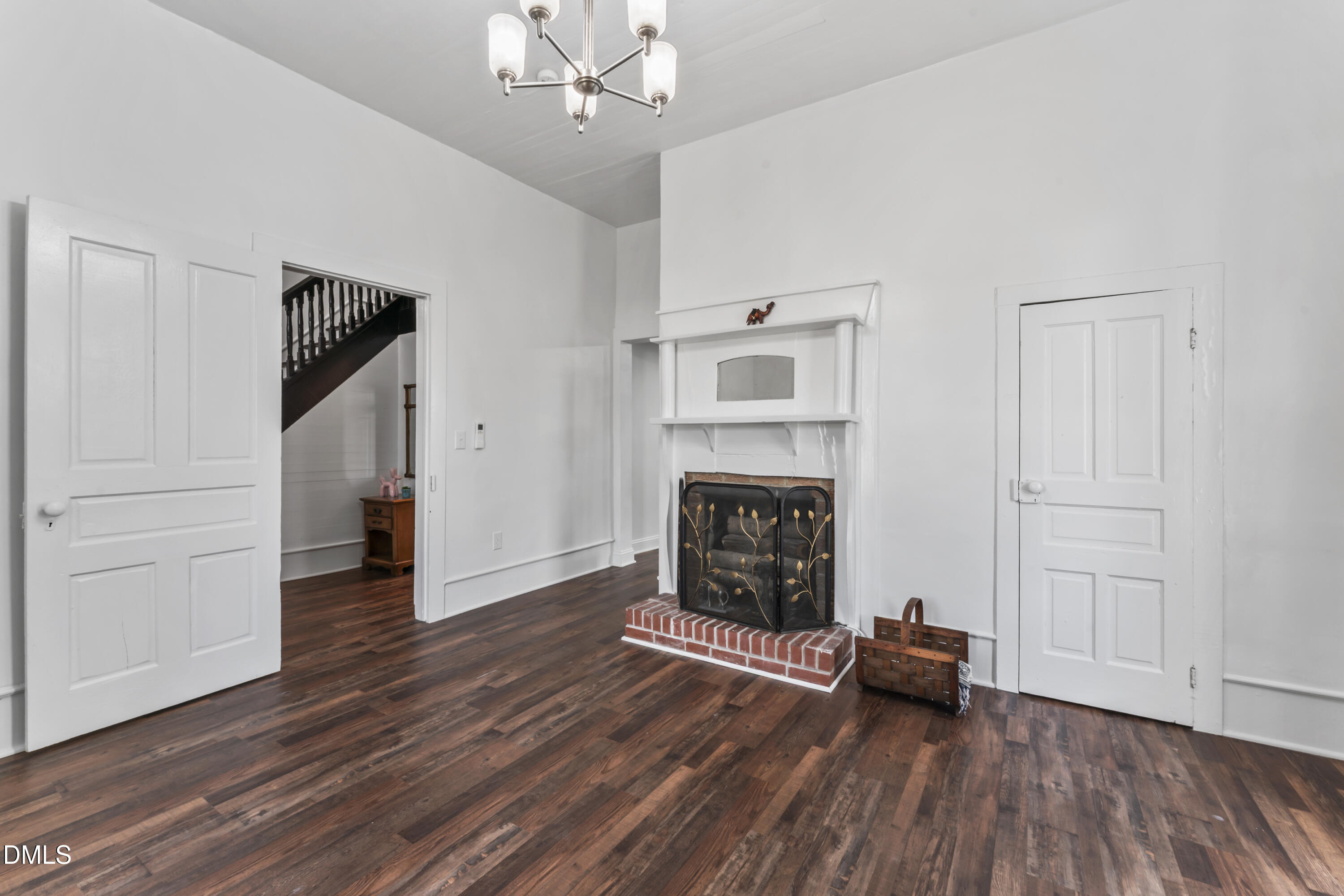 141 South Broad Street East Angier, NC 27501 - Photo 11 of 43 an empty room with wooden floor fireplace and windows