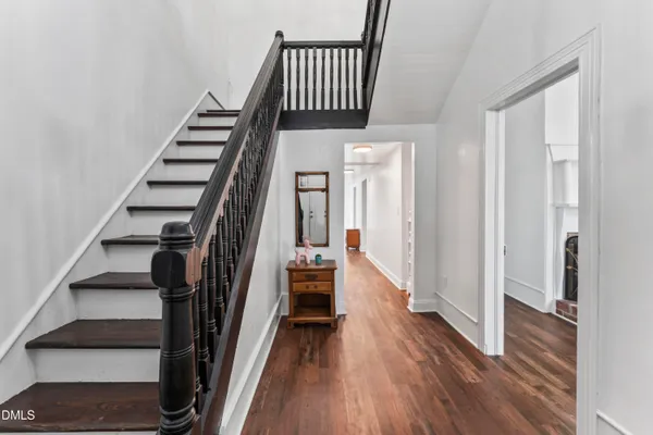 a view of a hallway with wooden floor and entryway