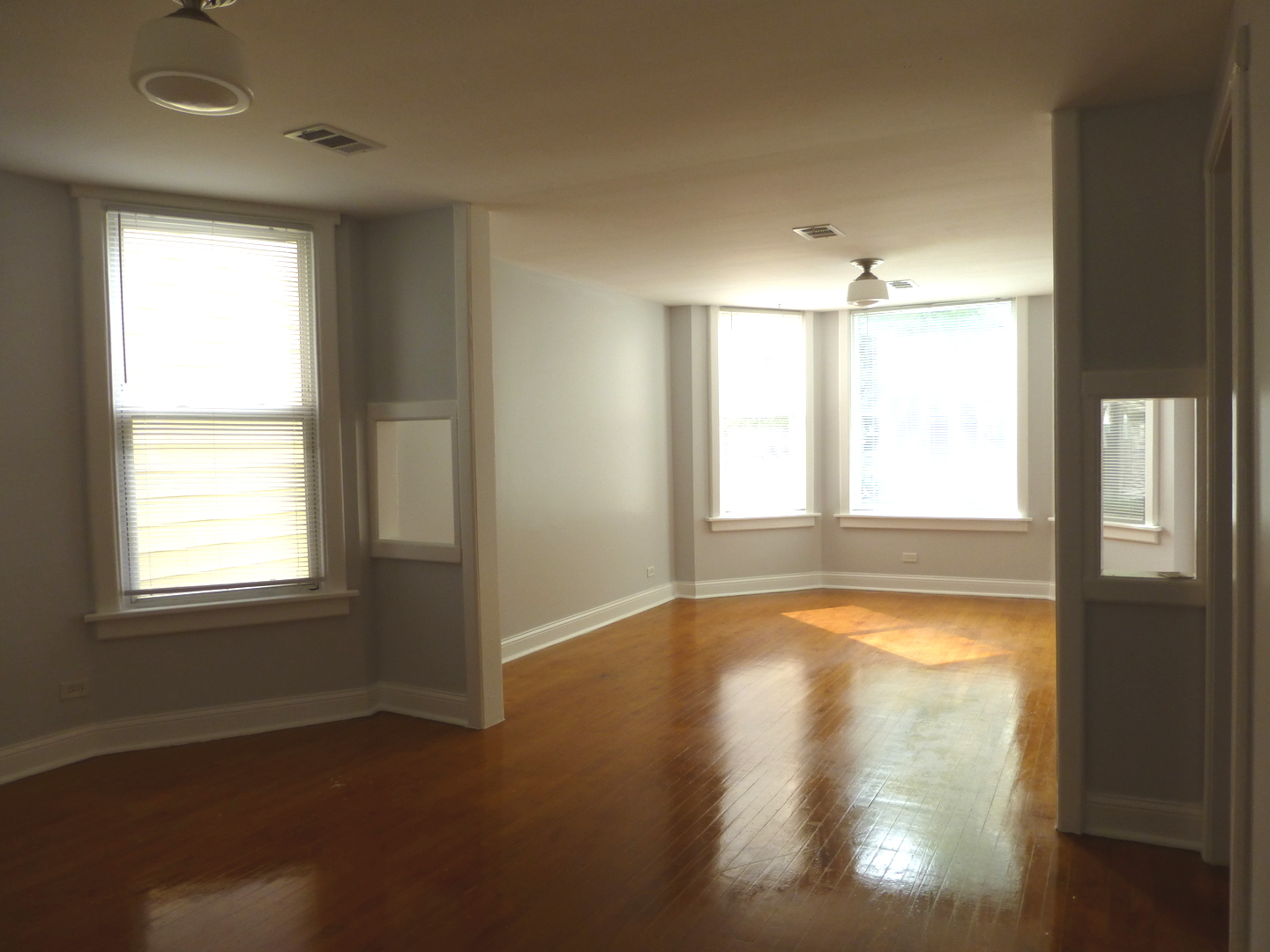 Undisclosed Address Chicago, IL 60647 - Photo 4 of 14 a view of an empty room with wooden floor and a window