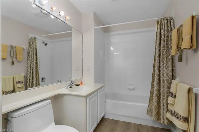 a bathroom with a bathtub shower sink vanity and a mirror