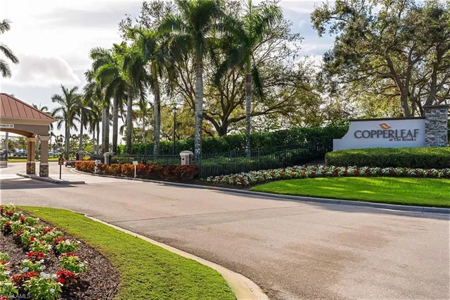 a view of a park that has a sign board with plants