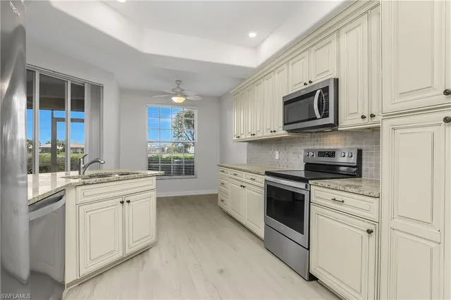 a kitchen with white cabinets stainless steel appliances and sink