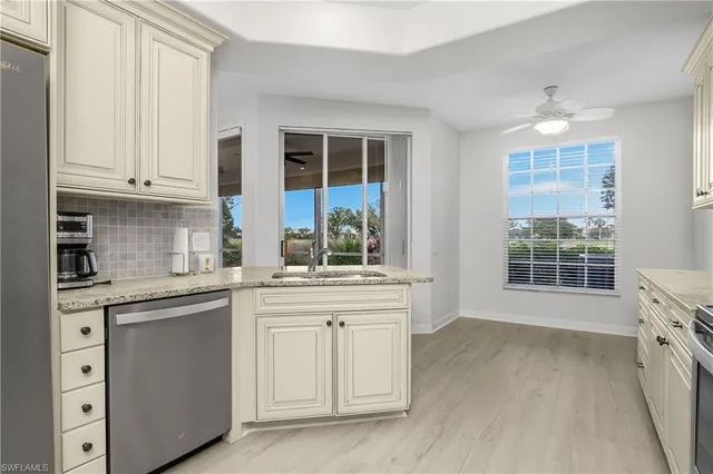 a kitchen with stainless steel appliances granite countertop a sink and cabinets with wooden floor