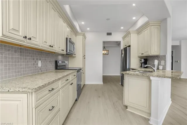 a kitchen with stainless steel appliances granite countertop a sink and cabinets