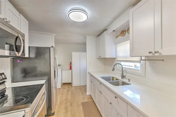 a kitchen with stainless steel appliances granite countertop a sink and a refrigerator