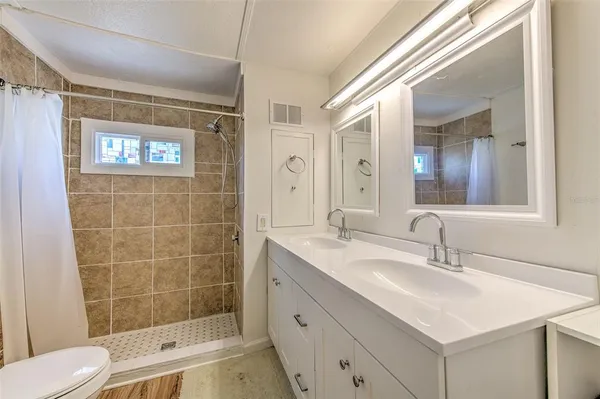 a bathroom with a sink a toilet and shower