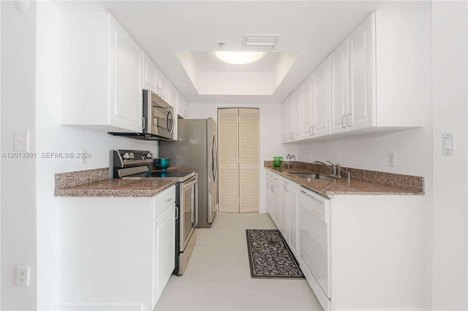 90 Alton Road, Unit 1007 Miami Beach, FL 33139 - Photo 12 of 25 a kitchen with stainless steel appliances granite countertop a sink stove and refrigerator