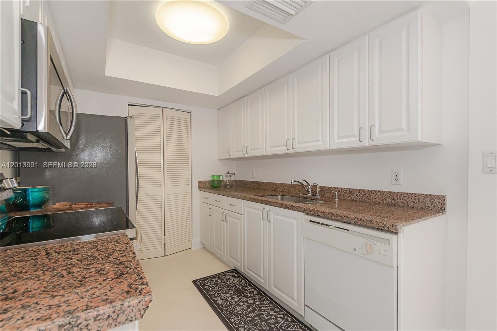 90 Alton Road, Unit 1007 Miami Beach, FL 33139 - Photo 13 of 25 a kitchen with stainless steel appliances granite countertop a sink stove and cabinets