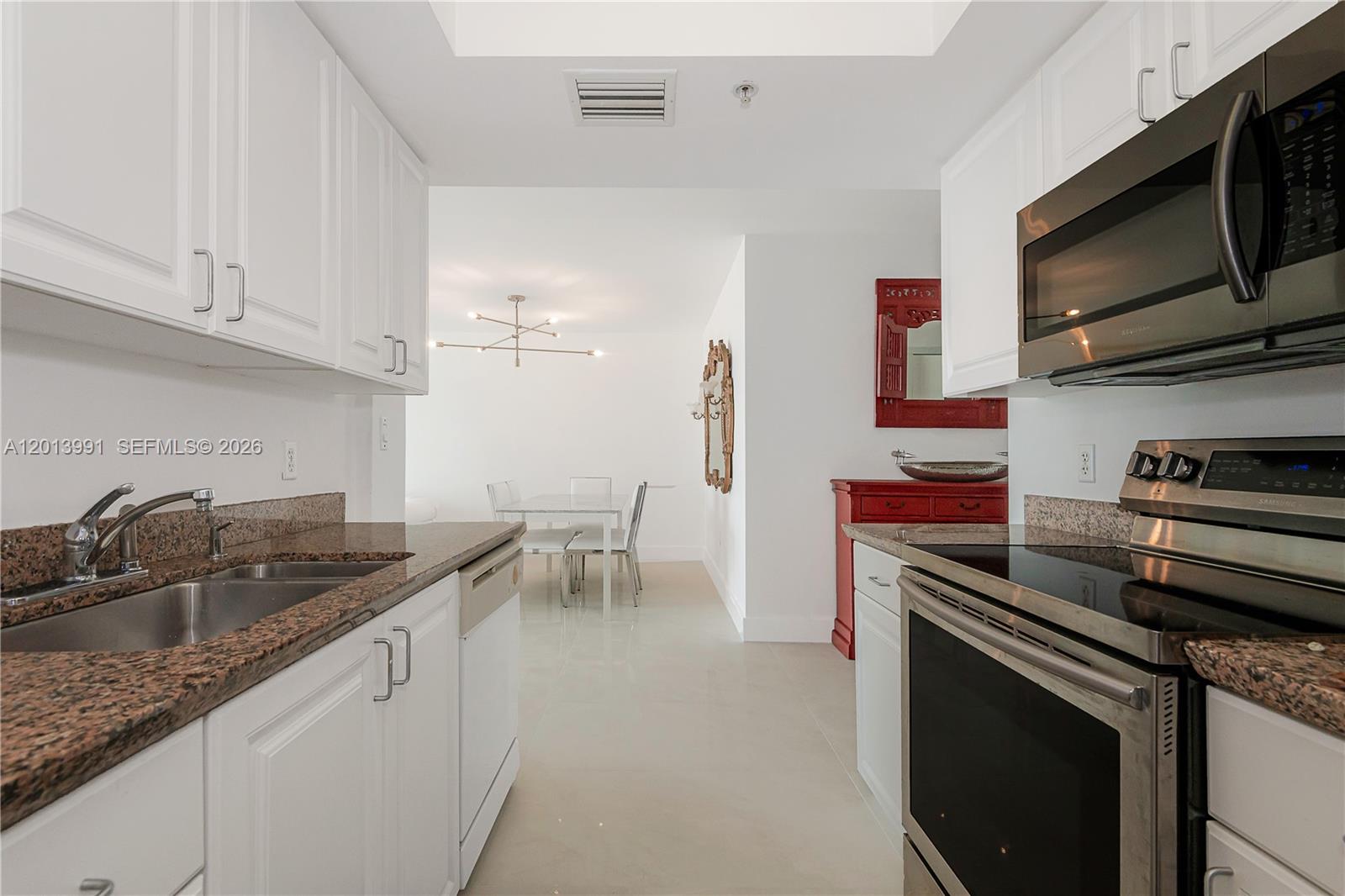 90 Alton Road, Unit 1007 Miami Beach, FL 33139 - Photo 15 of 25 a kitchen with stainless steel appliances granite countertop a sink stove and cabinets