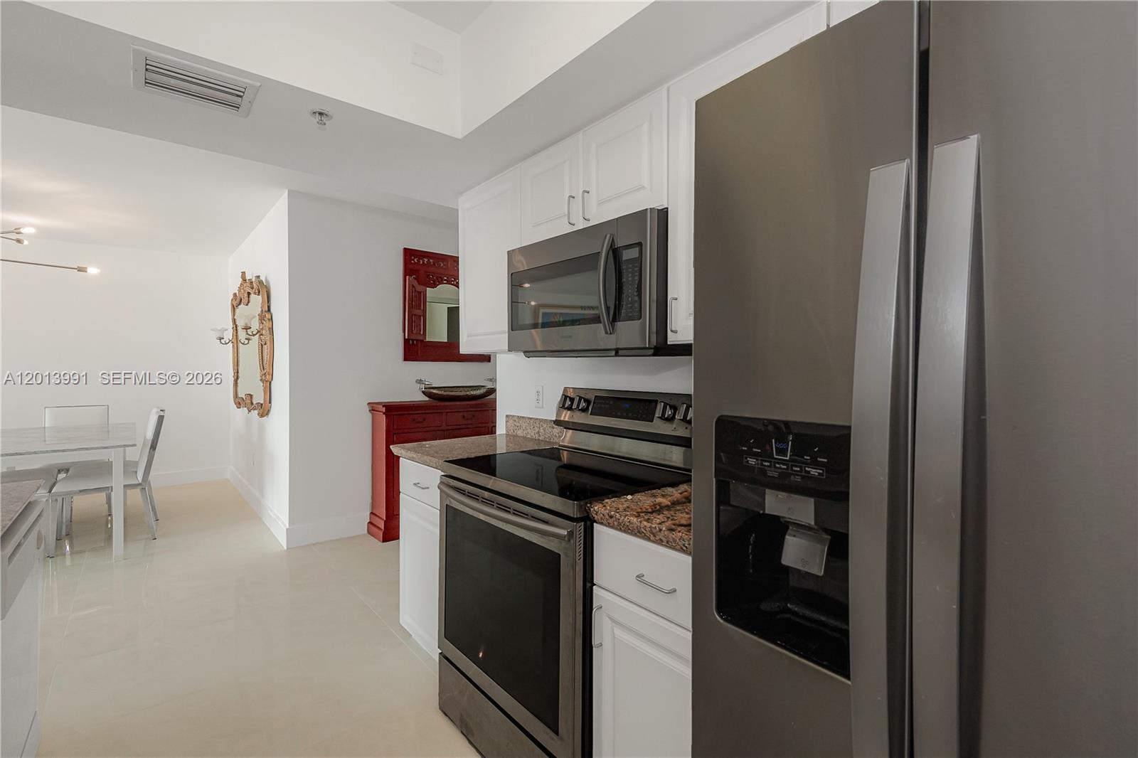 90 Alton Road, Unit 1007 Miami Beach, FL 33139 - Photo 16 of 25 a kitchen with a stove and a refrigerator