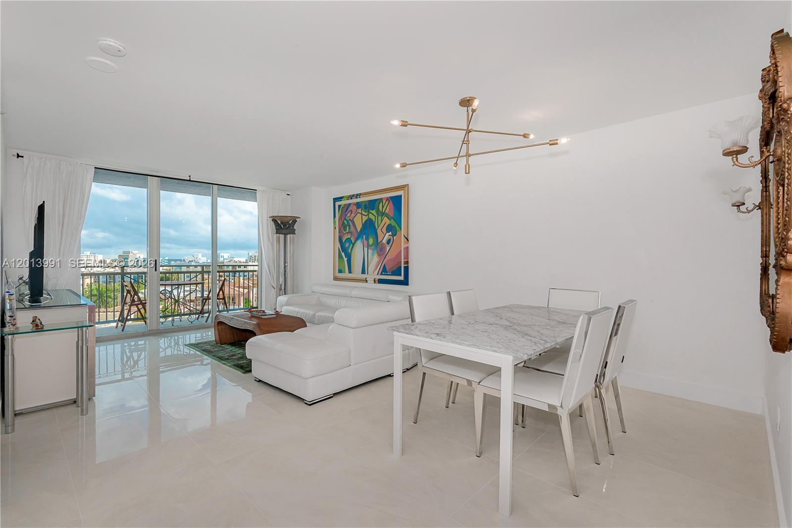 90 Alton Road, Unit 1007 Miami Beach, FL 33139 - Photo 2 of 25 a living room with furniture and a large window