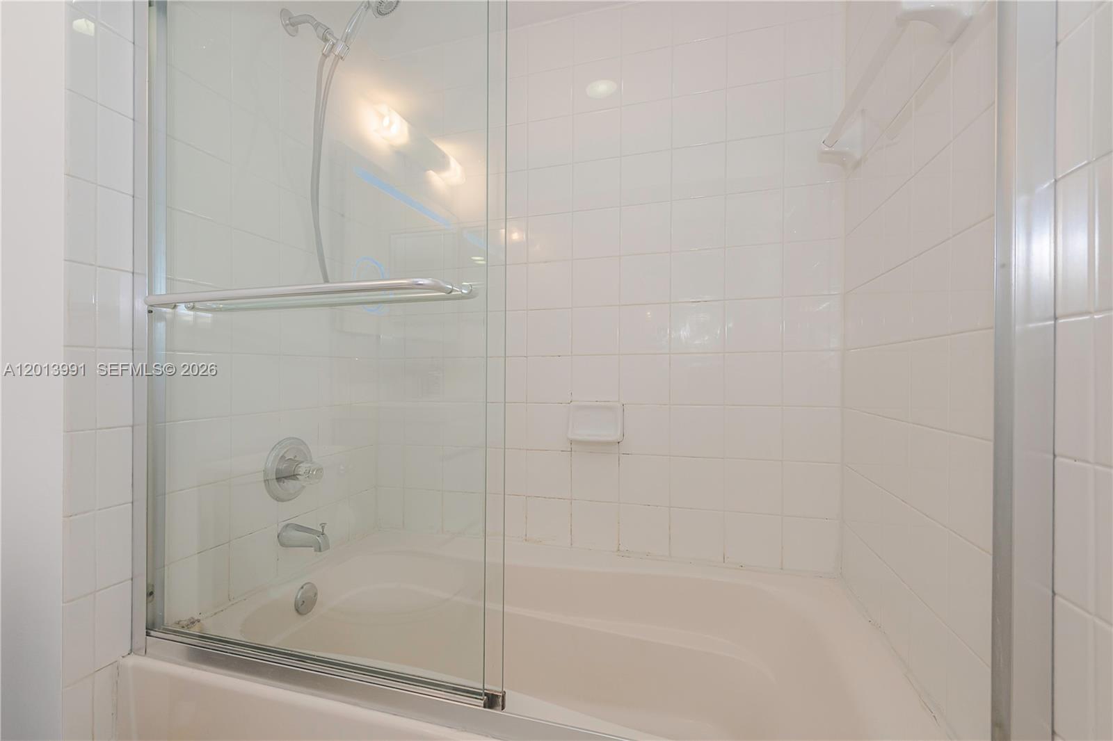 90 Alton Road, Unit 1007 Miami Beach, FL 33139 - Photo 22 of 25 a bathroom with a glass shower door