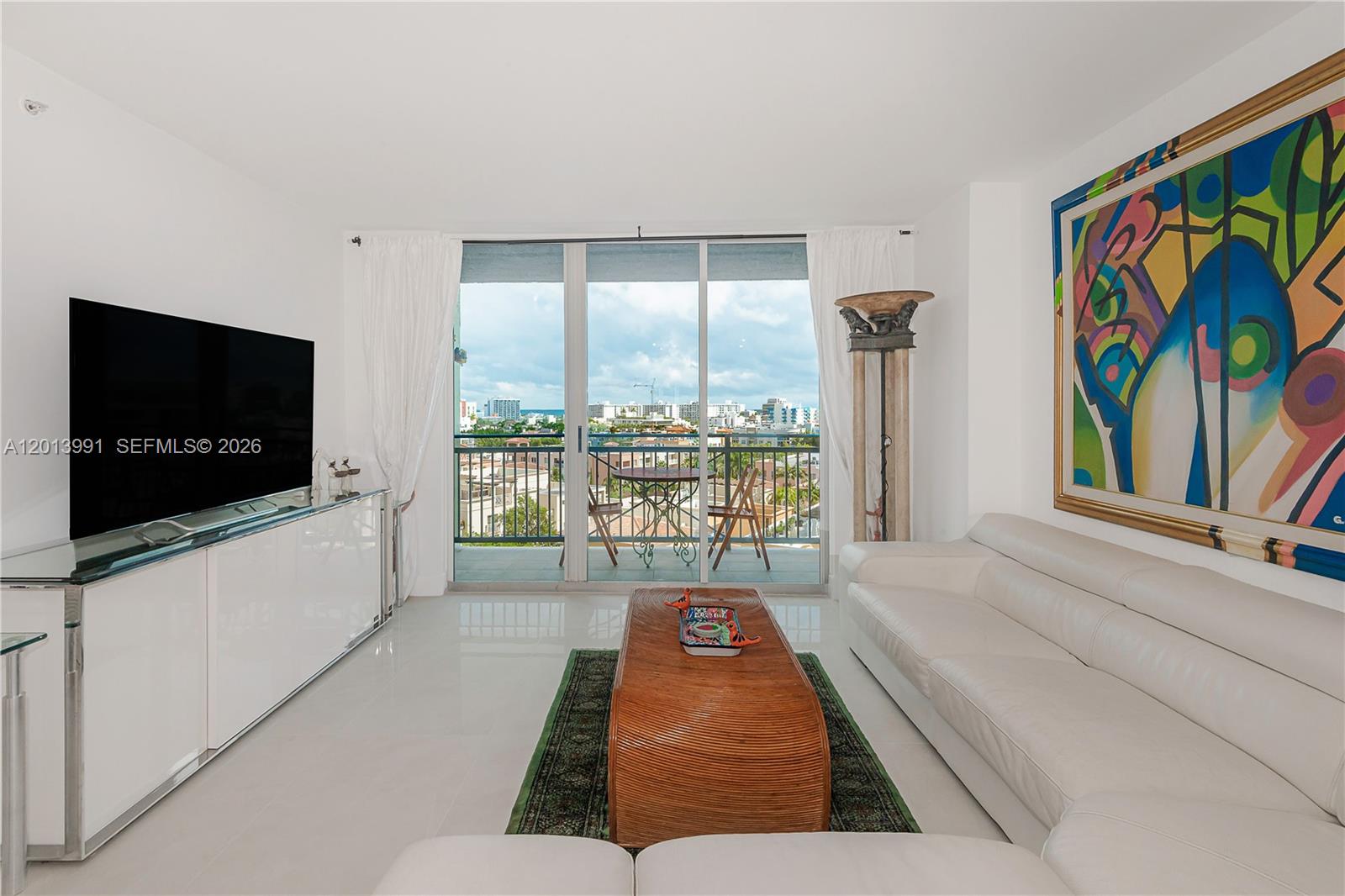 90 Alton Road, Unit 1007 Miami Beach, FL 33139 - Photo 8 of 25 a living room with furniture and a flat screen tv