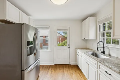 a kitchen with stainless steel appliances granite countertop a refrigerator a sink and a stove