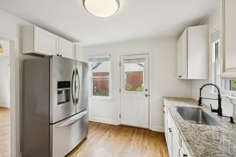 a kitchen with granite countertop a refrigerator and a sink
