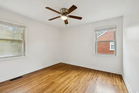 an empty room with a window and a ceiling fan