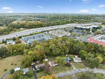 an aerial view of residential houses with outdoor space and trees
