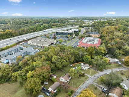 an aerial view of residential houses with outdoor space and trees