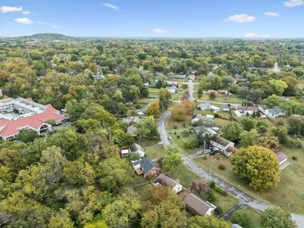 an aerial view of residential houses with outdoor space and trees