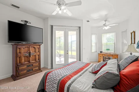 a bedroom with a bed ceiling fan and a window