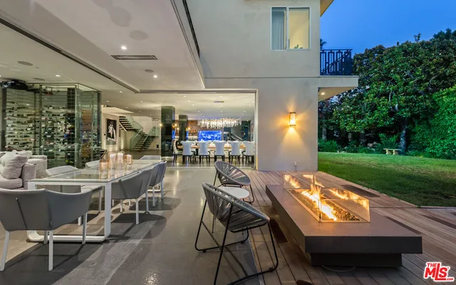 a view of a patio with couches table and chairs and potted plants