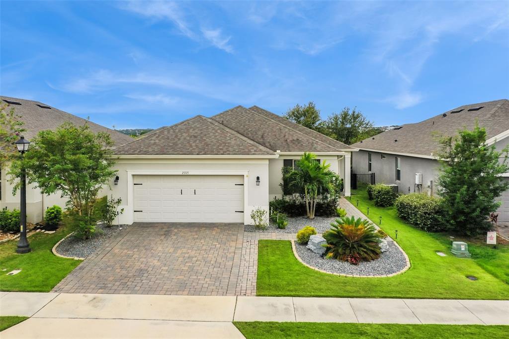 a view of a house with a yard and potted plants