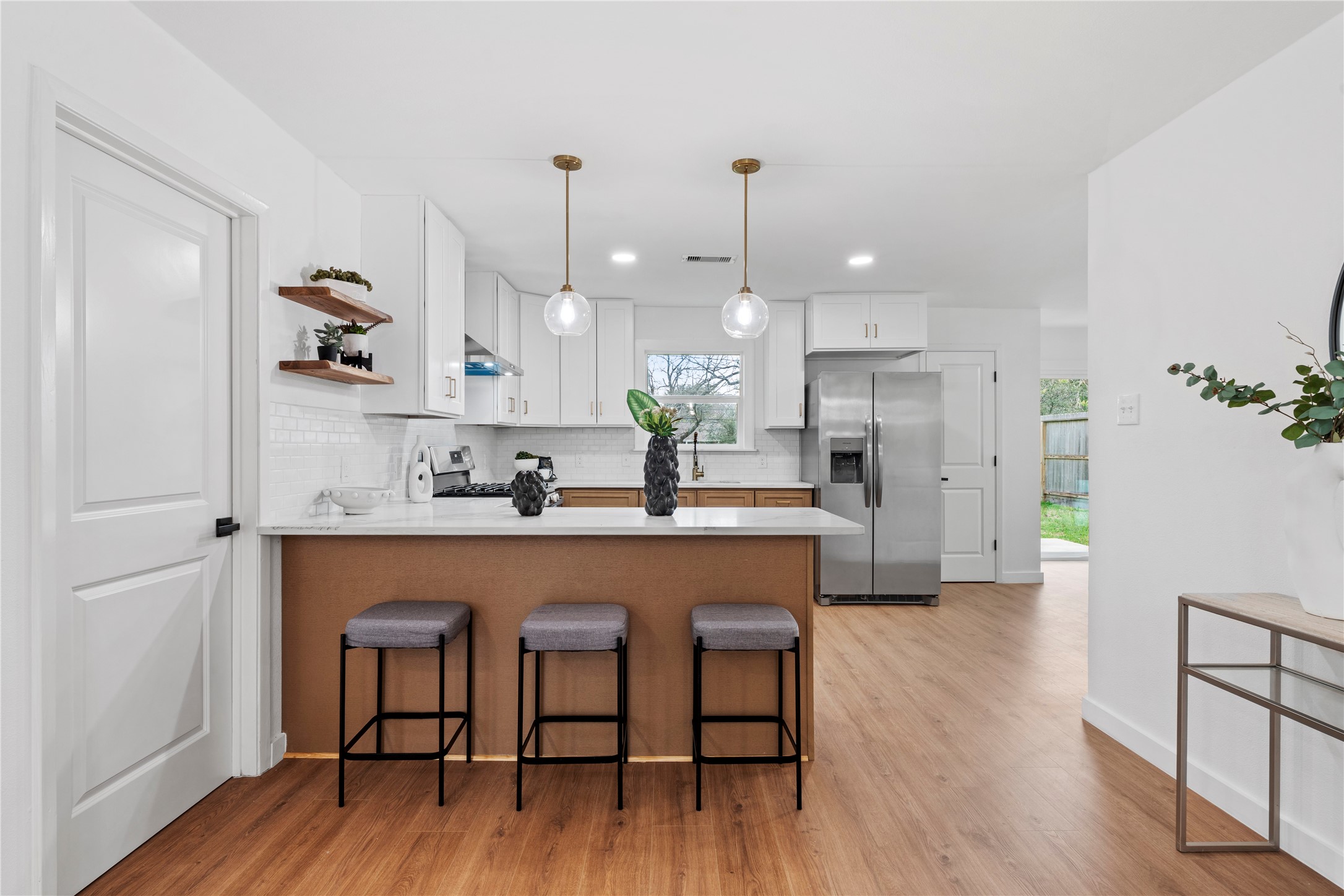5023 Redstart Street Houston, TX 77035 - Photo 12 of 34 The chef-inspired kitchen features a massive breakfast bar, sleek white cabinetry, and modern pendant lighting that adds a touch of elegance to the heart of the home.
