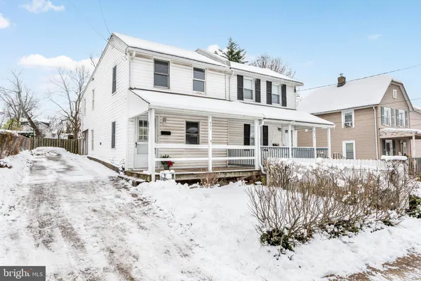 a front view of a house with a yard covered in snow